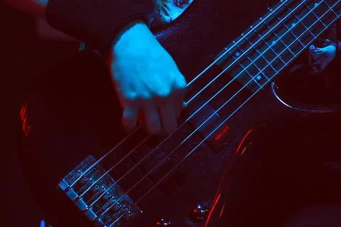 The bass player plays a five-string bass guitar Stock Photos