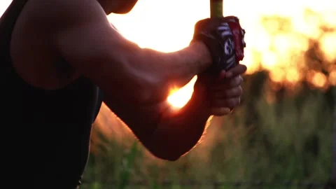 The bassist is practicing baseball bat catching with the sunset Stock Footage 133120656