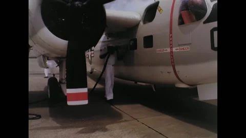 BATAAN - 1965 - Navy crewmen plug in power to a C-1A and officers put on Mae Stock Footage 328170534