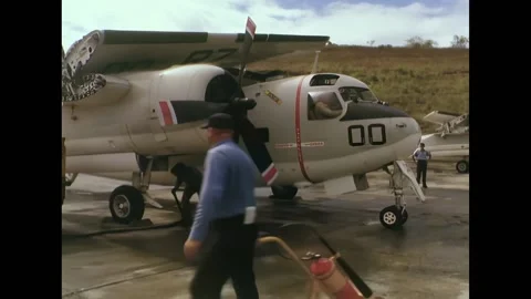 BATAAN - 1965 - A worker plugs in power to a C1-A, the engine starts, and wings Stock Footage 328170597
