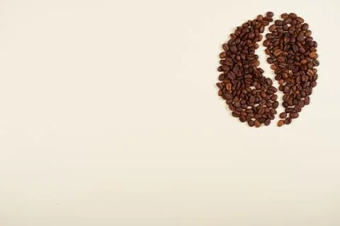 Batch of coffee beans laid in a shape of a coffee bean. Stock Photos