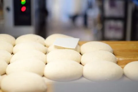 A batch of formed dough pieces on a table in the kitchen of a local bakery re Foto stock