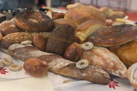 Batch of fresh baked buns and loafs on a market counter . Bread manufacture Stock Photos