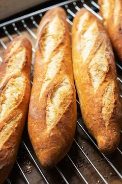 Batch of freshly baked baguettes background. Stock Photos
