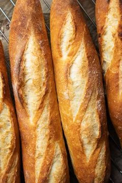 Batch of freshly baked baguettes background. Stock Photos