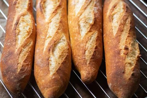 Batch of freshly baked baguettes background. Stock Photos