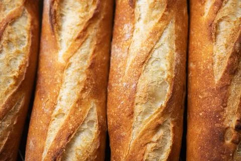 Batch of freshly baked baguettes background. Stock Photos