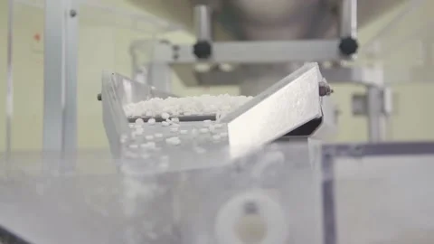 Batch of sorted pills are falling down to automated packing machine. medicine Stock Footage 200856549