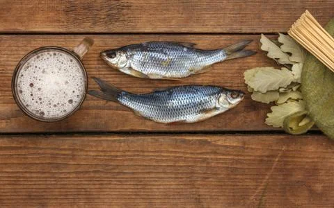 Bath accessories, foaming beer and traditional snack dried roach on wooden Stock Photos
