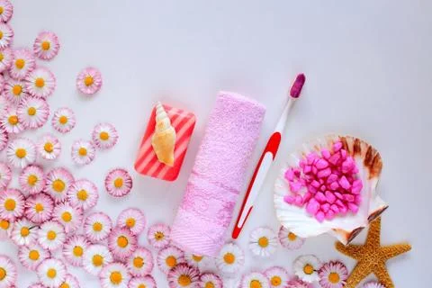 Bath accessories lie on a white background with spring flowers Stock Photos