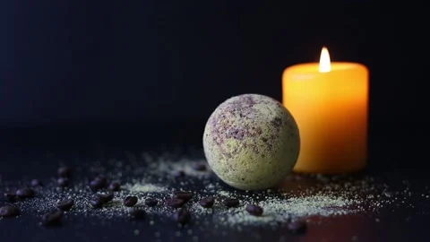 Bath bomb and coffee beans, with burning candles, on a dark background Stock Footage 158807712