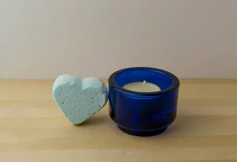Bath bomb in the shape of a heart and a candle Stock Photos