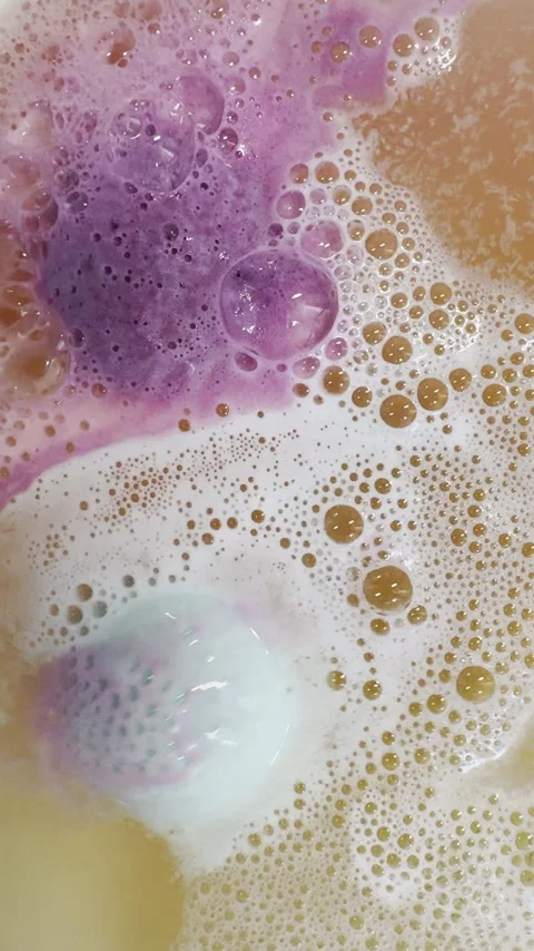 Bath bomb spins and creates fizzy bubbles in bathtub water Stock Footage 334762954