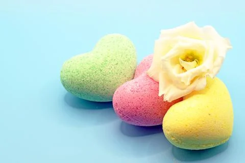 Bath bombs in the shape of a heart close-up on a blue background with an eust Stock Photos