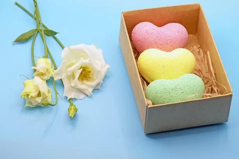 Bath bombs in the shape of a heart close-up on a blue background with an eust Stock Photos