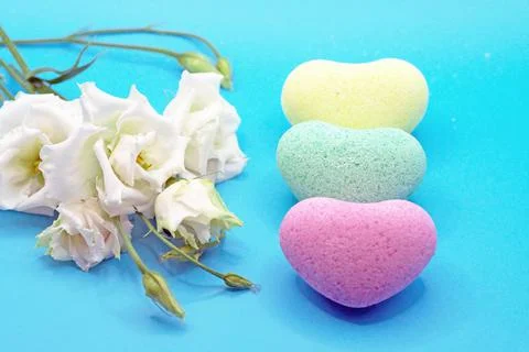Bath bombs in the shape of a heart close-up on a blue background with an eust Stock Photos