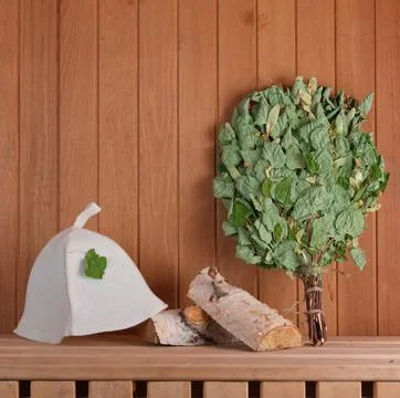 Bath broom, bath hat and Firewoods on the shelf in the sauna. Bathhouse Stock Photos