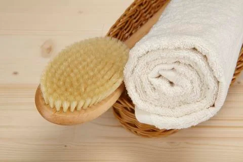 Bath brush and rolled towel in a basket Stock Photos