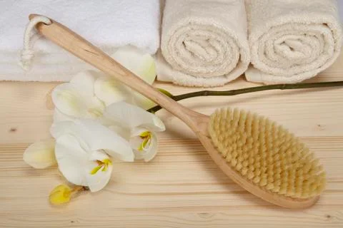 Bath brush and towels on a tabletop of spruce wood Stock Photos