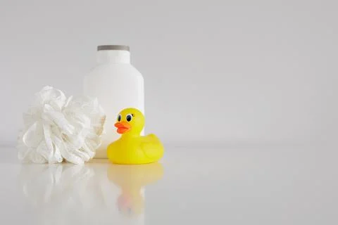 Bath concept - Sponge, douch gel and yellow duck on white table Stockfoto's