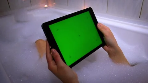 Bath with foam and tablet with a green screen Stock Footage 154209085