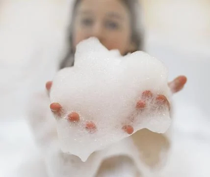 Bath foam. baby hands in bubble bath, baby washing in bubble bath Stock Photos