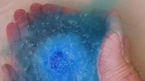 Bath salt ball dissolves in the hands. ball of salt dissolves in water Stock Footage 164125302