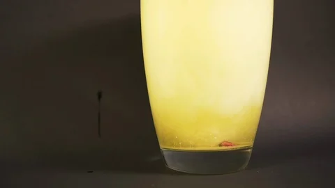 Bath salt closeup dissolves in vase of water in slow mo with particle drilling Stock Footage 119544088