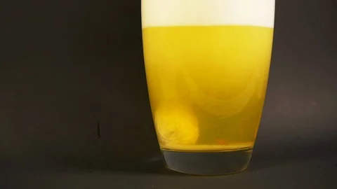 Bath salt yellow dissolves in vase of water in slowmotion with particle drilling Stock Footage 119544832