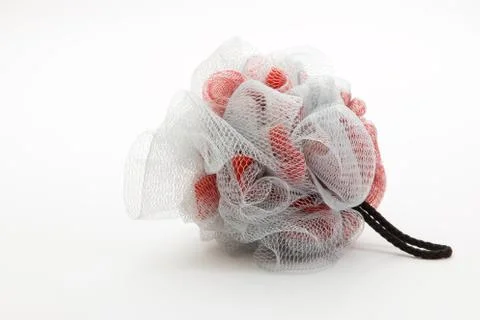 Bath scrubber puff in grey and red for exfoliation. Stock Photos
