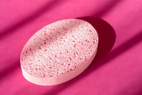 Bath sponge on purple surface. Oval spa shower scrub accessory. Skin care Foto stock