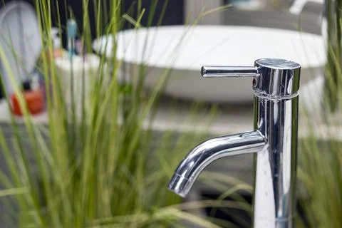 Bath tap and artificial plants 写真素材