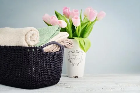 Bath towels of different colors in wicker basket Stock Photos