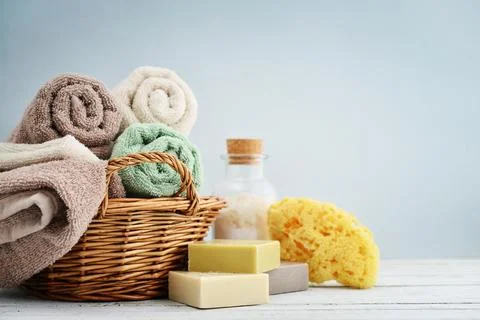Bath towels of different colors in wicker basket Stock Photos