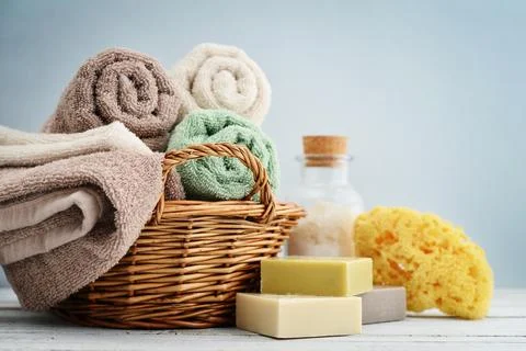 Bath towels of different colors in wicker basket Stock Photos