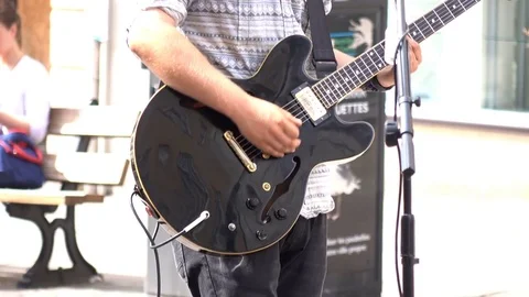 BATH, UK - AUGUST 12, 2017: Busker playing electric guitar as crowds pass by Stock Footage 83380213