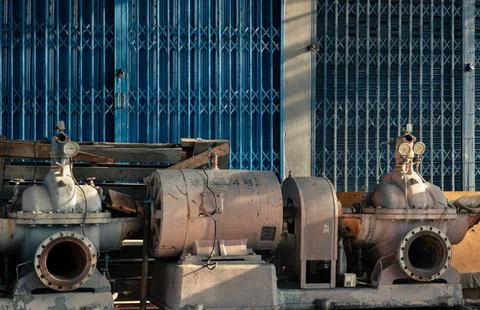 Bathed in the warm, low-angled light of late afternoon, a trio of heavy ind.. Stock Photos
