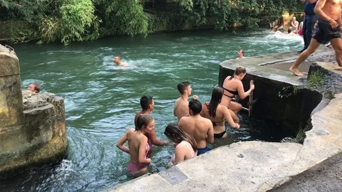 Bathers go ashore after a dangerous swim on a fast river in the city 動画素材 111564153
