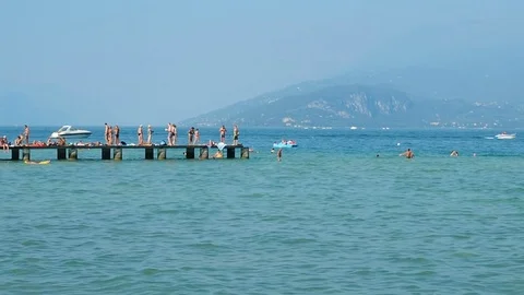 Bathers having fun on the pier at Gard lake Stock Footage 70611378