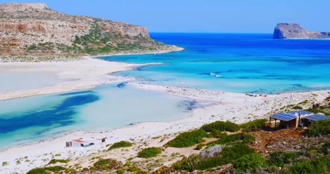 Bathers stroll through beautiful crystal clear waters beach with yellow sand  Video stock 246799558