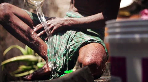 Bathing in slum with bucket Stock Footage 63556953
