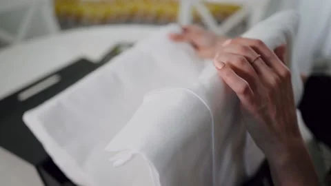 Bathrobe received a parcel with white bed linen. Opening a gift or surprise. Stock Footage 146661425