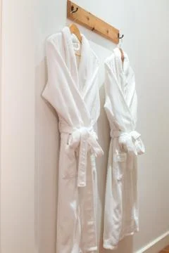 Bathrobes hanging on the wall Stock Photos