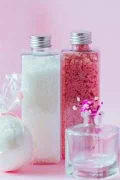Bathroom accessories in containers close-up on a pink background. Stock Photos