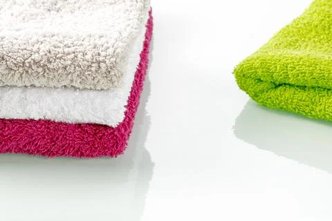 Bathroom accessories. Stack of soft terry colorful towels on a mirror background Stock Photos