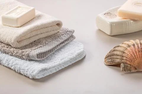 Bathroom accessories. Stack of towels, soap and shell on the dressing table Stock Photos