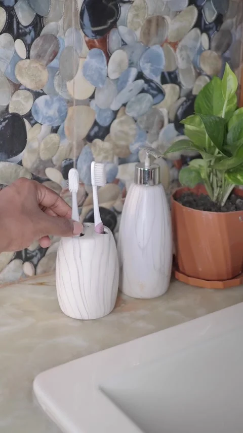 Bathroom decor with toothbrush holder and plants in a modern setting Stock Footage 345293463