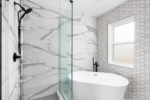 A bathroom detail with marble and pattern tile walls around a shower and soaking Stock Photos