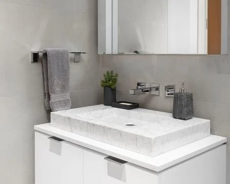 A bathroom detail with a marble, rectangular vessel sink. Stock-Fotos