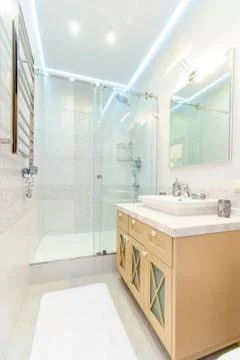 Bathroom with elegant rectangular washbasin, toilet and shower. Mirror with l Stock Photos